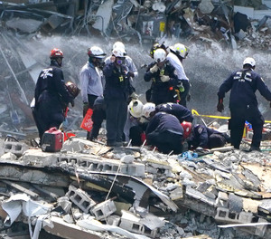 Rescue workers search the rubble of the Champlain Towers South condominium, Saturday, June 26, 2021, in the Surfside area of Miami. The building partially collapsed on Thursday.