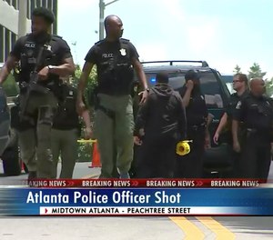 In this frame grab from video provided by WSB-TV in Atlanta, law enforcement personnel respond to a shooting Wednesday, June 30, 2021, in Atlanta, where authorities say two police officers responding to reports of gunfire in one of Atlanta's most famous neighborhoods were ambushed, leaving one of them shot and wounded and a suspect dead.