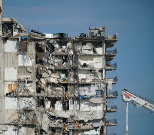 A parked crane sits beside the still standing section of Champlain Towers South, which partially collapsed last Thursday, as rescue efforts on the rubble below were paused out of concern about the stability of the remaining structure, Thursday, July 1, 2021, in Surfside, Fla. Scores of residents are still missing one week after the seaside condominium building partially collapsed.
