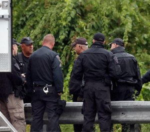 Police work on in the area of an hours long standoff with a group of armed men that partially shut down interstate 95, Saturday, July 3, 2021, in Wakefield, Mass.