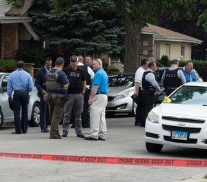 Chicago Police work on a crime scene in a residential neighborhood, Wednesday, June 7, 2021. Three undercover law enforcement officers were shot and wounded Wednesday morning while driving onto an expressway on Chicago’s South Side.