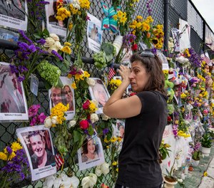 Gini Gonte visits the Surfside Wall of Hope & Memorial on Wednesday, July 7, 2021, as she honors her friends Nancy Kress Levin and Jay Kleiman, who lost their lives after the collapse of the Champlain Towers South in Surfside, Fla