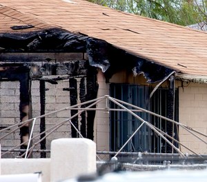 Tucson Police investigators work at the scene of a house fire where a body was found in Tucson, Ariz., Monday, July 19, 2021.
