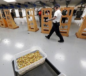 In this July 16, 2019, file photo, an officer taking part in training walks near a box of ammunition at the Washington State Criminal Justice Training Commission in Burien, Wash.