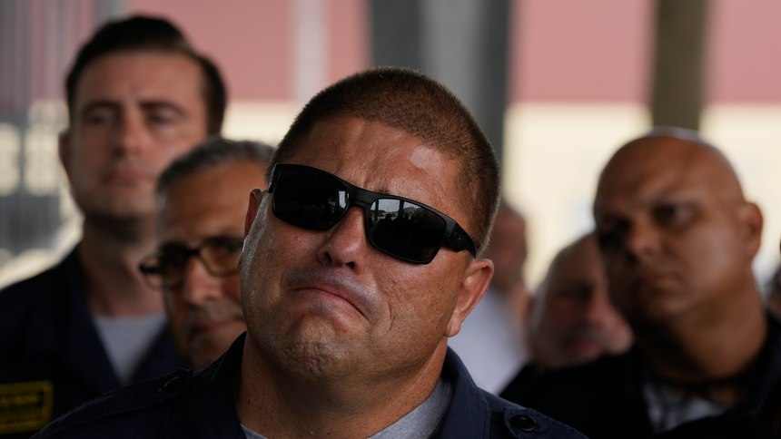 Members of Miami-Dade Fire Rescue's urban search and rescue team listen to officials lauding their efforts as they are welcomed back from a weeks-long deployment working on the rubble pile at the collapsed Champlain Towers South condominium, on Friday, July 23, 2021, in Doral, Fla.