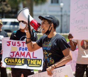 Elijah Whiteside leads protestors in a chant outside of Solicitor Scarlett Wilson's office in the Charleston County Judicial Center, Friday, May 21, 2021, in Charleston, S.C., to demand that the officers involved in the death of Jamal Sutherland be charged.