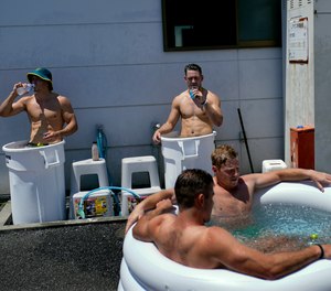 Members of Australia's men's rugby sevens team soak in ice baths following practice in the midday heat at the Tokyo 2020 Olympics, in Tokyo, Friday, July 23, 2021.