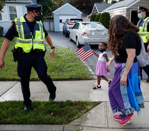 This photo from Monday July 13, 2020, shows Nassau County Police officers walk alongside protesters in Valley Stream, N.Y.