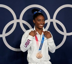 American gymnast Simone Biles poses wearing her bronze medal from balance beam competition during artistic gymnastics at the 2020 Olympics, Tuesday, Aug. 3, 2021, in Tokyo.