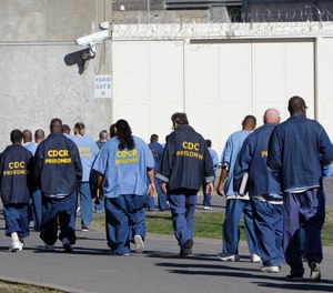 In this Feb. 26, 2013, file photo, inmates walk through the exercise yard at California State Prison Sacramento, near Folsom, Calif.