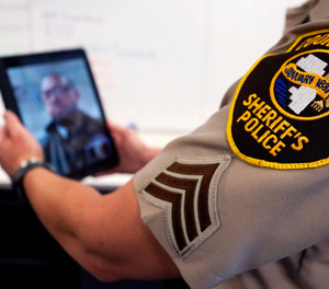 In this Friday, Aug. 13, 2021, photo Sheriff's Police Sgt. Bonnie Busching tests a virtual meeting with a tablet at the Cook County Sheriff's Office in Chicago.