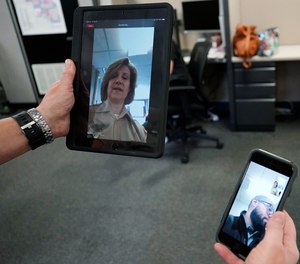 In this Friday, Aug. 13, 2021, photo Sheriff's Police Sgt. Bonnie Busching tests a virtual meeting from her tablet to her teammate cellphone at the Cook County Sheriff's Office in Chicago. The Cook County Sheriff's department officers are hitting the streets with tablets that can connect people in distress immediately with mental health professionals. And Cook County Sheriff Tom Dart says the Treatment Response Team has been successful bringing calm to the tensest of domestic situations involving people at risk of hurting themselves or others.