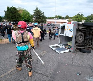 A van that was driven by anti-fascist protesters is pictured flipped on its side with all windows smashed after it was attacked for trying to drive into a Proud Boys rally Sunday, Aug. 22, 2021, in Portland, Ore.