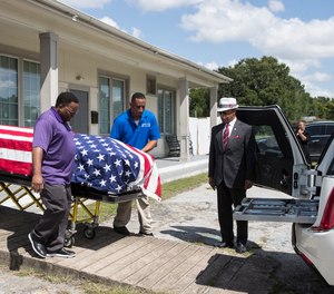 The body of New Orleans Police detective Everett Briscoe is placed into a hearse before it is escorted from the Respect for Life Funeral Home for the journey back to New Orleans, Tuesday, Aug. 24, 2021, in Houston.