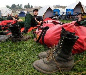 Firefighters from Oregon-based Grayback Forestery rest at a camp for firefighters battling the Okanogan Complex Fire in Okanogan, Wash.