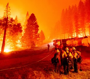 The Caldor Fire burns along both sides of Highway 50 as firefighters work to stop its eastward spread in Eldorado National Forest, Calif.