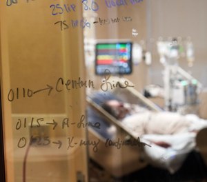 Medical notations are written on a window of a COVID-19 patient's room in an intensive care unit at the Willis-Knighton Medical Center in Shreveport, La.