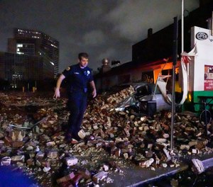 New Orleans Police detective Alexander Reiter, looks over debris from a building that collapsed during Hurricane Ida in New Orleans, Monday, Aug. 30, 2021.
