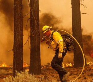 A firefighter battles the Caldor Fire along Highway 89, Tuesday, Aug. 31, near South Lake Tahoe, Calif.