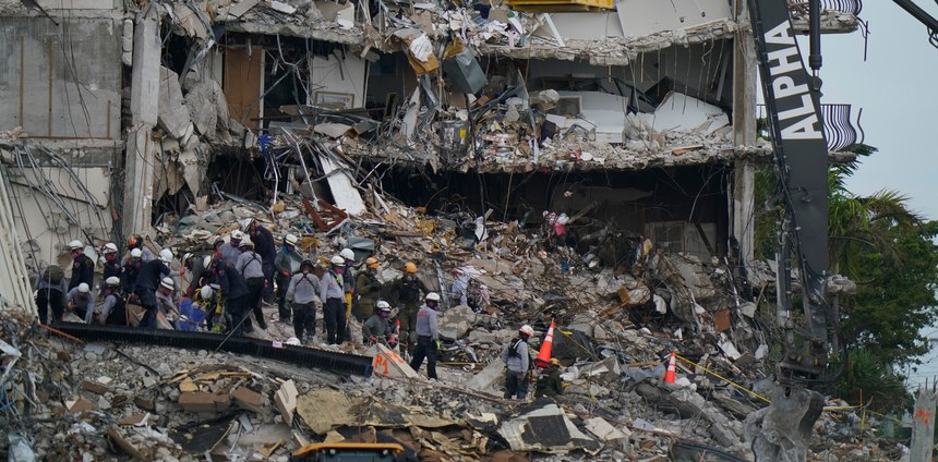 SAR personnel work atop the rubble at the Champlain Towers South condo building in Surfside, Fla.