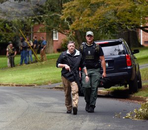 Law enforcement officers search the Foxhall neighborhood behind Mount Tabor High School in Winston-Salem, N.C., after a shooting that left one student dead, Wednesday, Sept. 1, 2021.