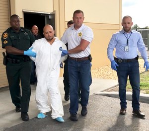 Quadruple murder suspect Bryan Riley is led from the Polk County Sheriff’s Office in Lakeland, Fla., on Sunday, Sept. 5, 2021, by Deputy Steve Neil, left, Captain Bart Davis and Detective Brett Bulman.