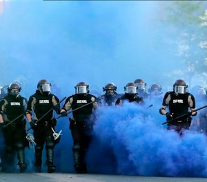 In this May 30, 2020, file photo, Minnesota State Police officers approach a crowd of protesters in Minneapolis.