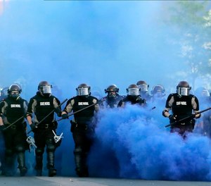 In this May 30, 2020, file photo, Minnesota State Police officers approach a crowd of protesters in Minneapolis. The mass demonstrations in 2020 were also unprecedented in terms of numbers, size and levels of violence.
