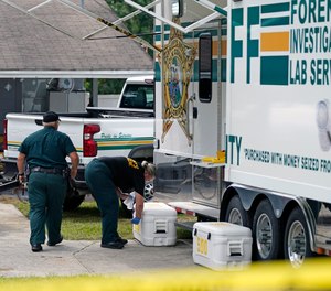 Officers from the Polk County Sheriff Department work outside Tuesday, Sept. 7, 2021, in Lakeland, Fla., at the home where a family of four was shot and killed.