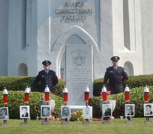 In this Sept. 13, 2005 file photo, Larry Hale, left, and John Molnar, from the New York State Department of Corrections, stand on guard in front of a monument and photos in honor of the victims of the Attica Correctional Facility prison uprising in 1971.