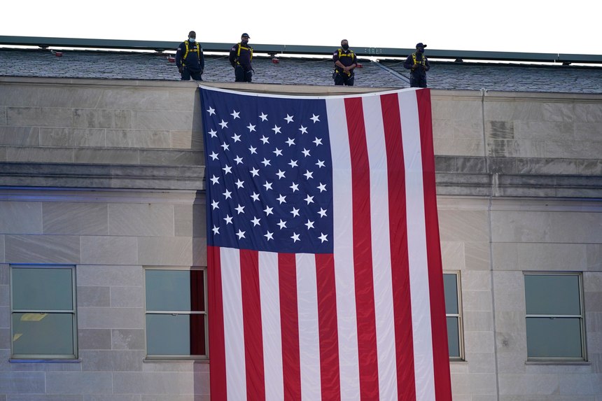 An American flag is unfurled at the Pentagon in Washington, Saturday, Sept. 11, 2021, at sunrise on the morning of the 20th anniversary of the terrorist attacks. The American flag is draped over the site of impact at the Pentagon.
