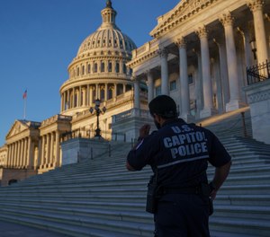 A U.S. Capitol Police officer stands at the steps of the Senate at dawn in Washington, Monday, Sept. 27, 2021.