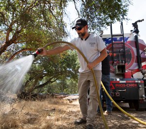Eric Clancy applies a long-lasting fire retardant at former President Ronald Reagan's coastal mountain ranch in the Santa Ynez mountains.