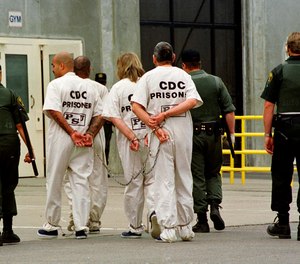 In this Oct. 28, 1999, photo, a group of inmates is moved from one cell unit to another at California State Prison Sacramento, in Folsom, Calif.