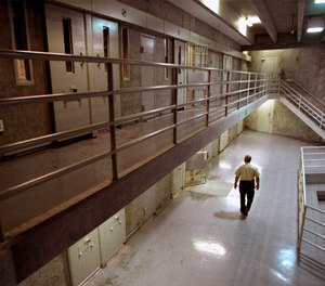 In this Oct. 28, 1999, file photo a correctional officer walks through a housing unit during a lockdown at California State Prison, Sacramento, in Folsom, Calif.