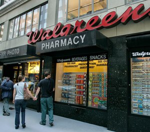In this June 26, 2006 file photo, window shoppers look at a Walgreens storefront in San Francisco. Walgreens planned to close five more stores in San Francisco because of organized retail theft.
