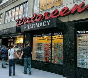 In this June 26, 2006 file photo, window shoppers look at a Walgreens storefront in San Francisco. Walgreens planned to close five more stores in San Francisco because of organized retail theft.