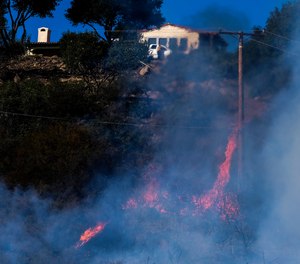 The Alisal Fire burns near a home in Goleta, Calif.
