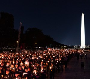Hundreds of candles are held up during the National Law Enforcement Officers Memorial Fund's Annual Candlelight Vigil, on the National Mall, Thursday, Oct. 14, 2021, in Washington.