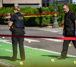 In this July 17, 2021, file photo, police investigate an overnight fatal shooting in Portland, Ore.