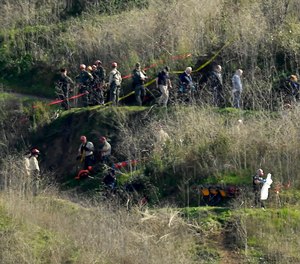 In this Jan. 27, 2020, file photo, investigators work the scene of a helicopter crash that killed former NBA basketball player Kobe Bryant in Calabasas, Calif.