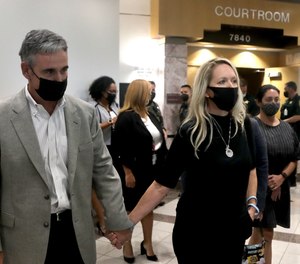 Gena and Tom Hoyer, the parents of murder victim Luke Hoyer, leave the courtroom in Fort Lauderdale, Fla. on Wednesday, Oct. 20, 2021, after the shooter pleaded guilty to murder in the 2018 massacre that left 17 dead.