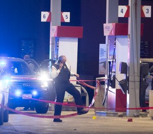 Chicago police officers investigate a shooting incident at a gas station in Lyons, Il., Wednesday, Oct. 20, 2021.