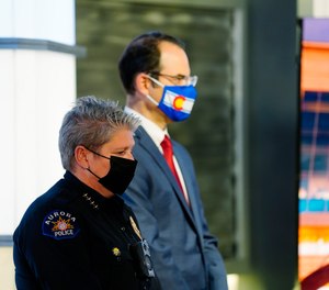 Vanessa Wilson, chief of the Aurora, Colo., Police Department, joins Colorado Attorney General Phil Weiser in listening during a news conference about the consent decree Tuesday.