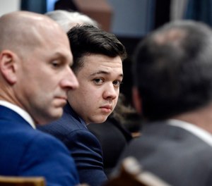 Kyle Rittenhouse, center, looks over to his attorneys as the jury is dismissed for the day during his trial at the Kenosha County Courthouse in Kenosha, Wis., on Thursday, Nov. 18, 2021.