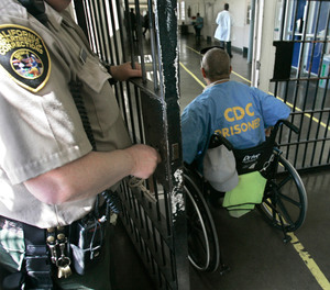 A wheelchair-bound inmate wheels himself through a checkpoint at the California Medical Facility in Vacaville, Calif., on April 9, 2008.