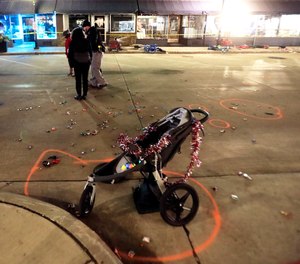 A broken children's stroller lays on W. Main St. in downtown Waukesha, Wis., after an SUV drove into a parade of Christmas marchers Sunday, Nov. 21, 2021.