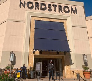 A security guard stands outside the Nordstrom store at The Grove retail and entertainment complex in Los Angeles, Tuesday, Nov. 23, 2021.