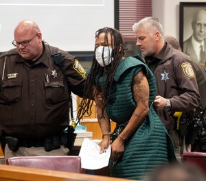 Darrell Brooks, center, is escorted out of the courtroom after making his initial appearance, Tuesday, Nov. 23, 2021 in Waukesha County Court in Waukesha, Wis. Prosecutors in Wisconsin have charged Brooks with intentional homicide in the deaths of at least five people who were killed when an SUV was driven into a Christmas parade.