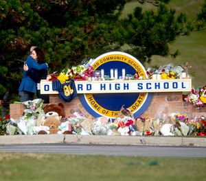 Gov. Gretchen Whitmer embraces Oakland County Executive Dave Coulter as the two leave flowers and pay their respects Thursday morning, Dec. 2, 2021 at Oxford High School in Oxford, Mich. A 15-year-old boy has been denied bail and moved to jail after being charged in the Michigan school shooting that killed four students and injured others.